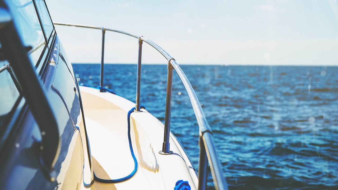 Detail van luxe jacht op open zee onder helderblauwe lucht, symbool voor goed onderhouden luxe bezittingen
